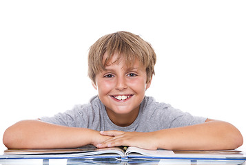 Image showing Smiling boy with  book on the table 