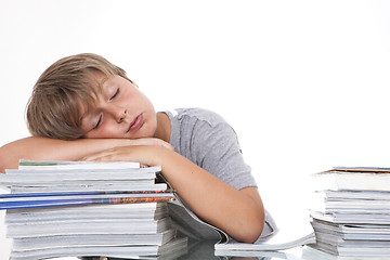 Image showing Tired student at the desk, isolated on white 