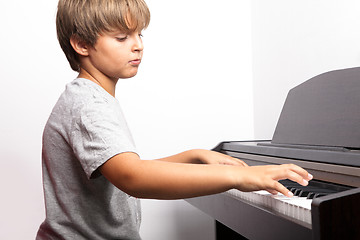 Image showing Young boy playing piano 