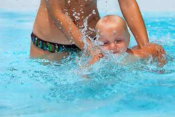 Image showing Child having fun in water with mom. 