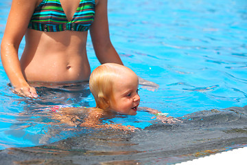 Image showing Child having fun in water with mom.