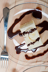 Image showing fresh cream cake closeup with chocolate sauce