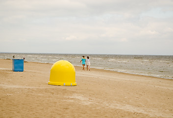 Image showing Recycling waste bins on sea coast and people walk 