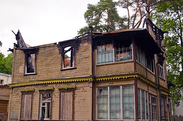 Image showing Abandoned old wooden retro house with burnt roof 