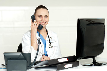 Image showing Beautiful nurse talking on phone with patient