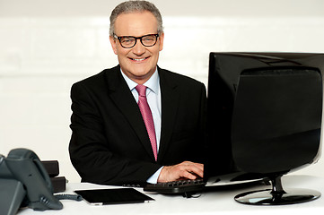 Image showing Happy aged corporate man typing on keyboard