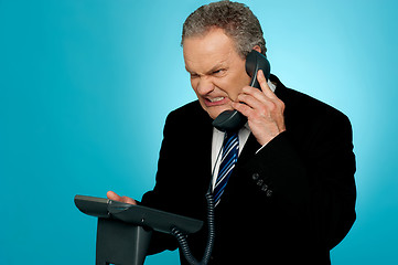 Image showing Irritated businessman communicating on phone