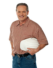 Image showing Smiling senior architect holding white safety hat