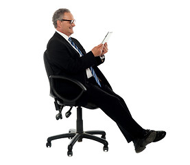 Image showing Well dressed corporate male holding wireless tablet