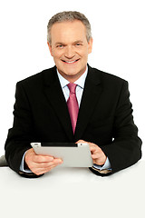 Image showing Handsome aged business male using tablet pc