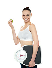 Image showing Attractive woman with apple and weight scale