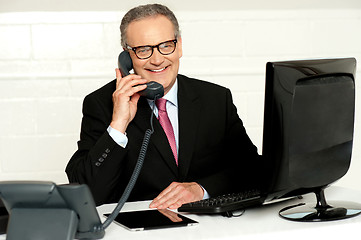 Image showing Senior businessman attending phone call