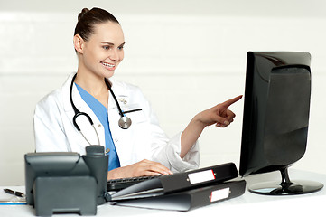 Image showing Female medical expert pointing at computer screen