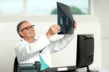 Image showing Senior surgeon in glasses looking at x-ray