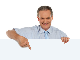 Image showing Casual male promoter pointing at blank billboard