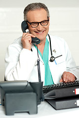Image showing Matured physician communicating on phone