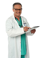 Image showing Cheerful doctor using wireless tablet device