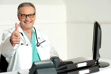 Image showing Smiling doctor gesturing thumbs up to camera