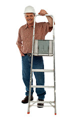 Image showing Smiling construction worker holding ladder