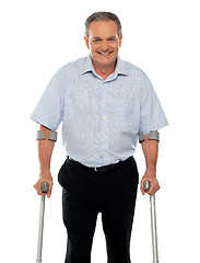 Image showing Senior man standing with support of crutches