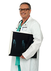 Image showing Smiling doctor carrying x-ray report of hand bone