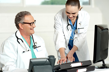 Image showing Smiling medical team working on computer