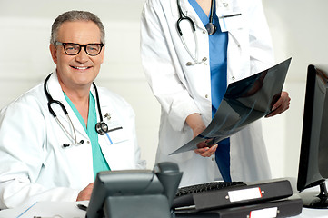 Image showing Woman assistant presenting x-ray report to male doctor