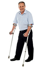 Image showing Senior man standing with the help of crutches