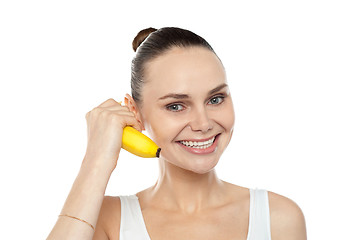 Image showing Girl doing call gesture using banana as cellphone