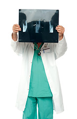 Image showing Male surgeon hiding his face with x-ray report