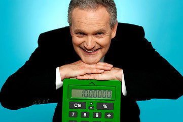 Image showing Aged corporate male resting face on big calculator