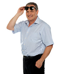 Image showing Casual man holding sunglasses over his head