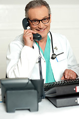 Image showing Happy aged medical expert taking on phone