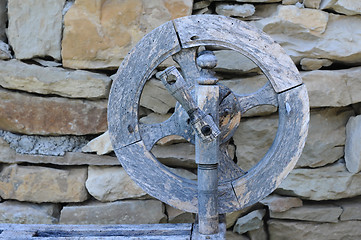 Image showing Retro Spinning Wheel Against Stone Wall Background