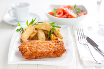 Image showing Schnitzel with wedges and tomato salad