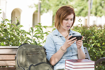 Image showing Stunned Young Female Student Outside Texting on Cell Phone