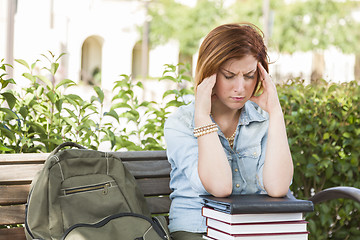 Image showing Female Student Outside with Headache Sitting with Books and Back