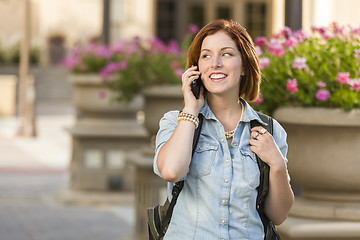 Image showing Young Female Student Walking Outside Using Cell Phone