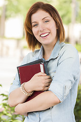 Image showing Smiling Young Female Student Outside with Books