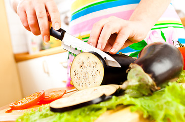 Image showing Woman's hands cutting aubergine eggplant