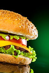 Image showing Tasty and appetizing hamburger on a darkly green