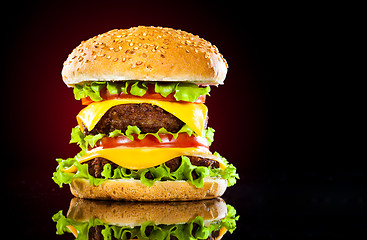 Image showing Tasty and appetizing hamburger on a darkly red