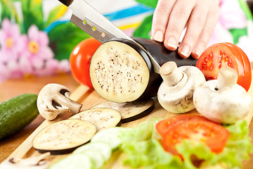 Image showing Woman's hands cutting aubergine eggplant