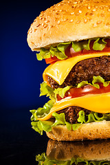Image showing Tasty and appetizing hamburger on a dark blue