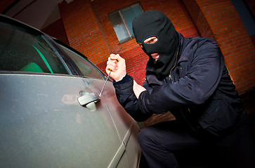 Image showing robber and the thief in a mask hijacks the car