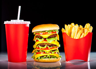 Image showing Tasty hamburger and french fries on a dark