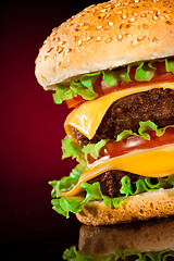 Image showing Tasty and appetizing hamburger on a darkly red