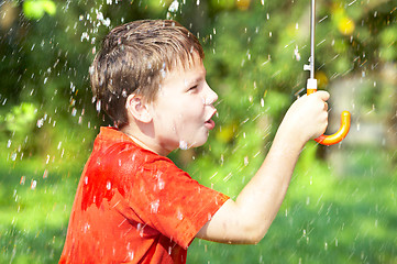 Image showing boy under an umbrella during a rain