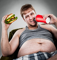 Image showing fat man eating hamburger