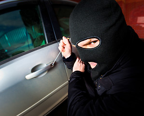 Image showing robber and the thief in a mask hijacks the car